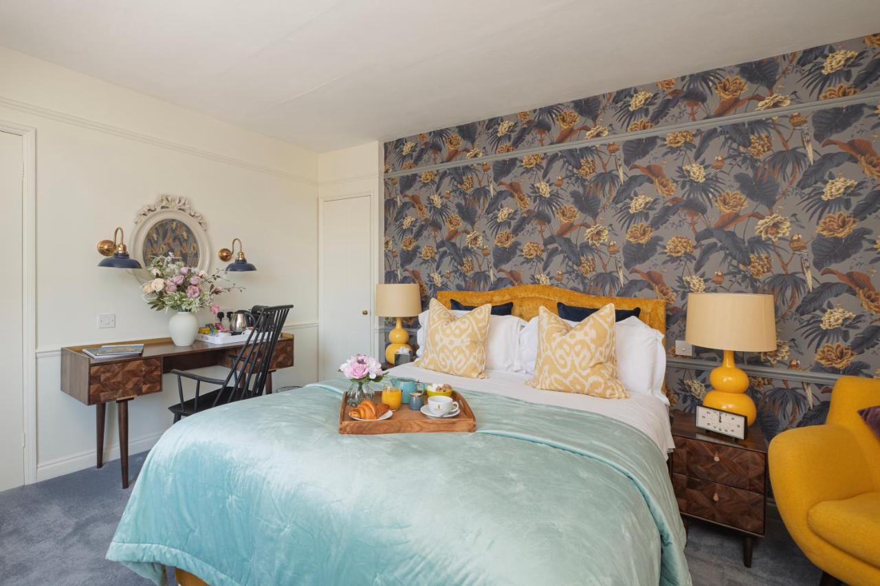 a bedroom with a large bed with a floral wallpaper at Harington's Boutique Hotel in Bath