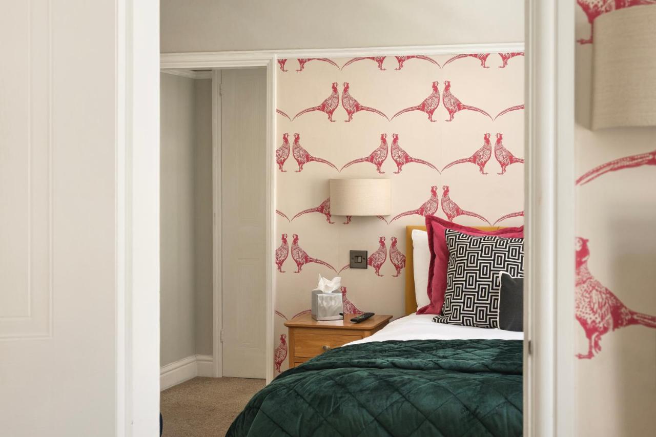 a bedroom with a bed with a green comforter at Harington's Boutique Hotel in Bath
