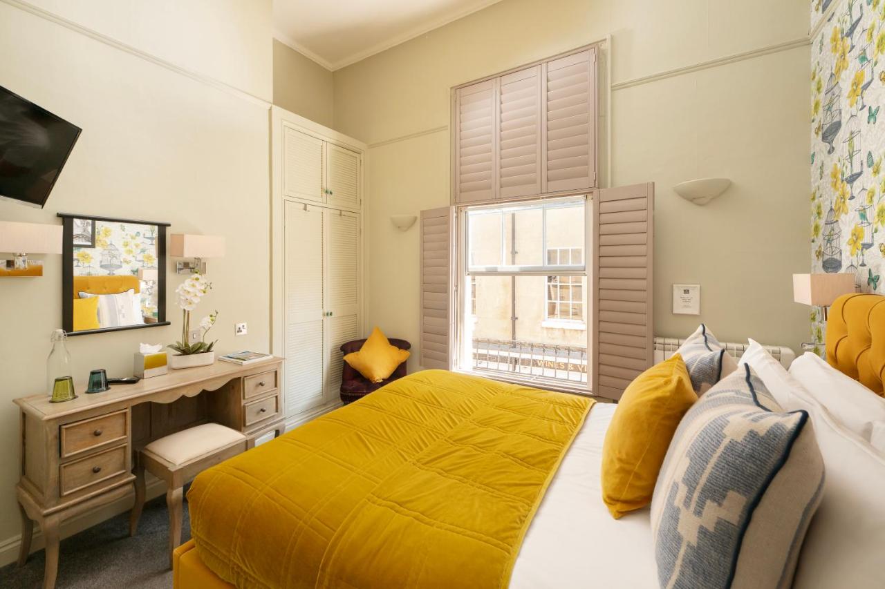a bedroom with a yellow bed and a desk and a window at Harington's Boutique Hotel in Bath
