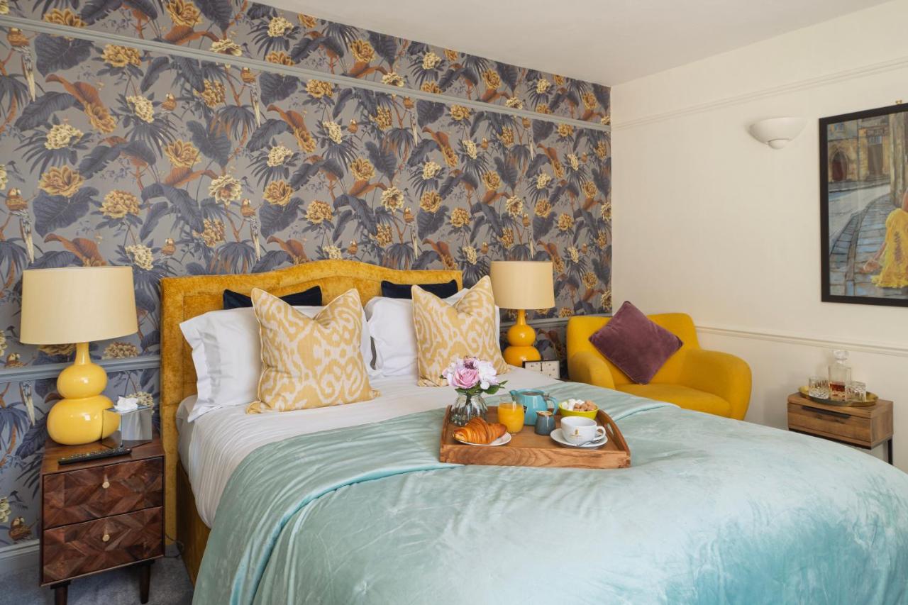 a bedroom with a bed with a tray of food on it at Harington's Boutique Hotel in Bath