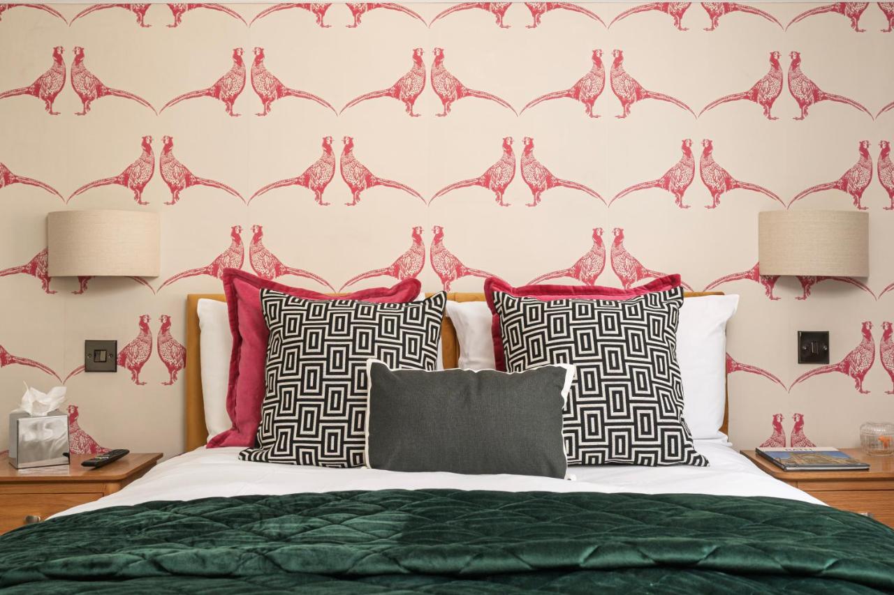 a bedroom with a bed with red and black pillows at Harington's Boutique Hotel in Bath